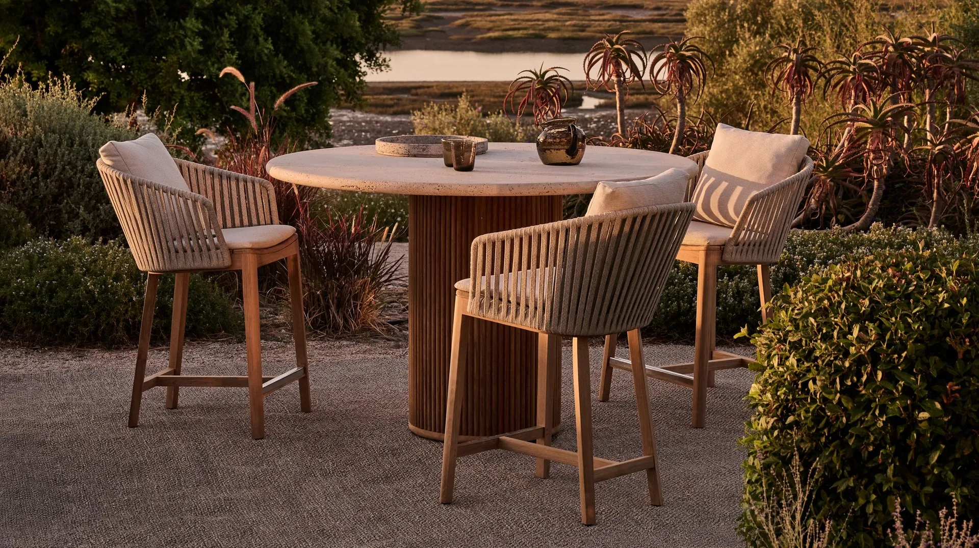Tribù Mood counter-height chairs in teak and woven Tricord around a round table in a garden