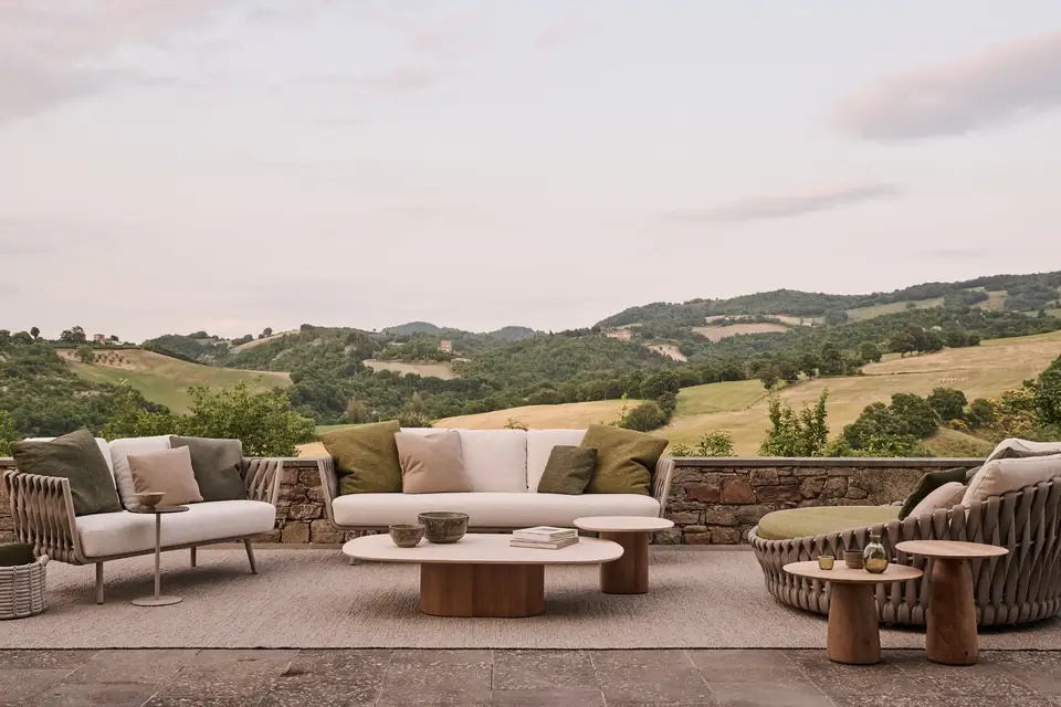 Tribù Tosca sofa, lounge chair and round braided daybed on a stone terrace above a valley